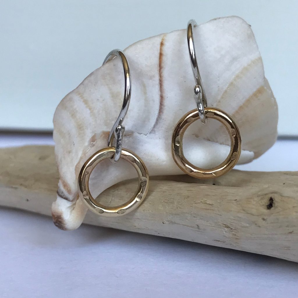 Drop Earrings in 9ct Gold hanging on a shell