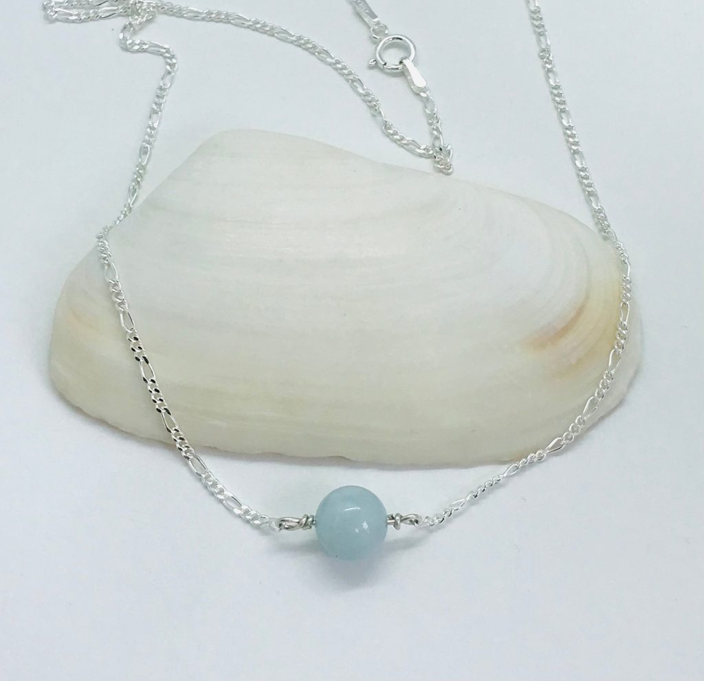 Aquamarine Orb Necklace on a large shell